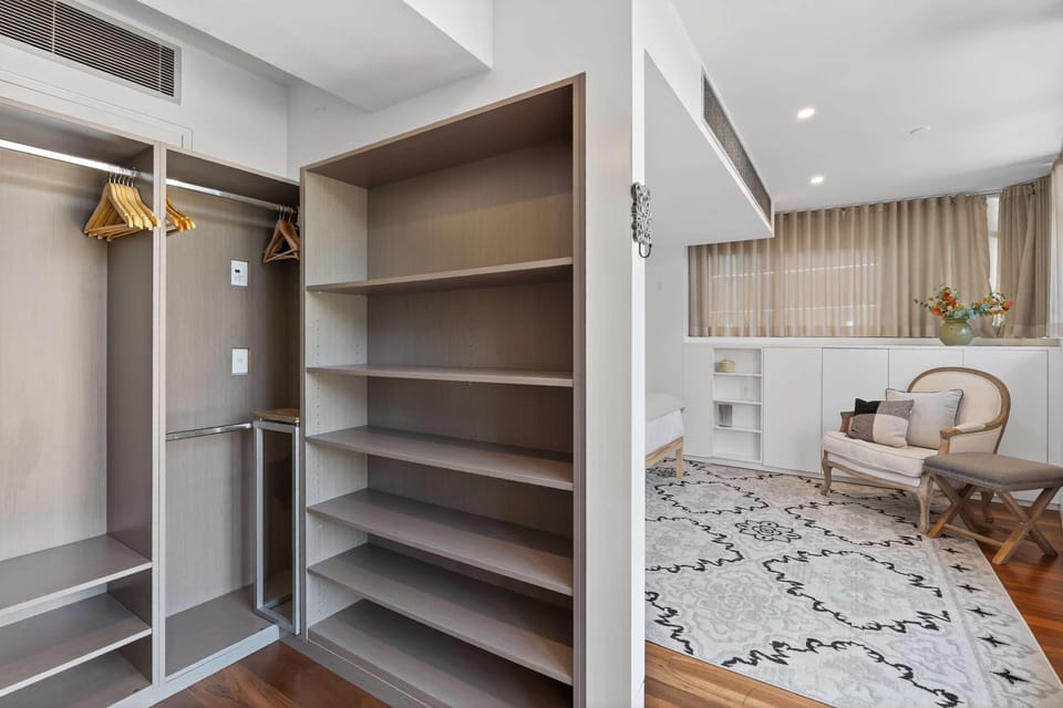Spacious upper-level main bedroom with a queen bed and walk-in wardrobe. The bathroom is located just outside the room for easy access.