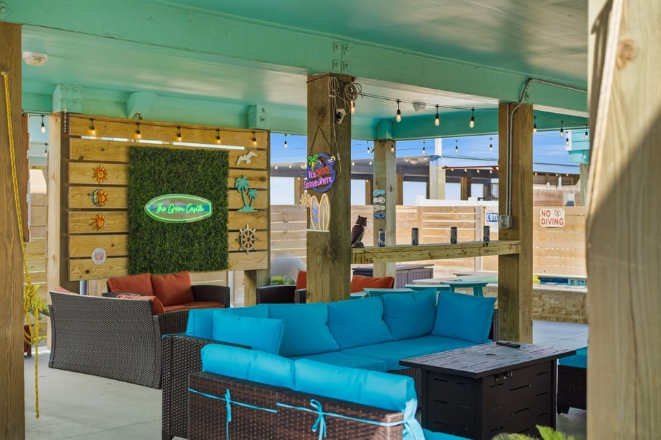 Ground Level — Teal Sofas, 'Green Casita' Neon, 'It's 5:00 Somewhere' Sign & Fire Pit
