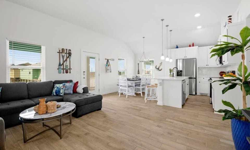 Living Room to Kitchen — Dark Sectional, Marble Coffee Table, Oar Art & White Kitchen Island