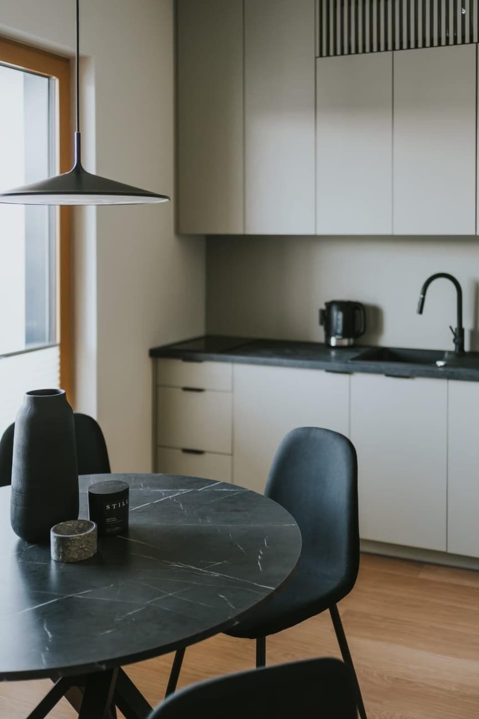 Kitchen and dining area with table, chairs, and modern appliances. The layout is functional and stylish.
