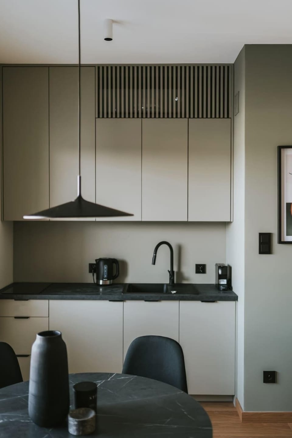 Kitchen with dining table and chairs. Black and white accents complement the clean, modern aesthetic.