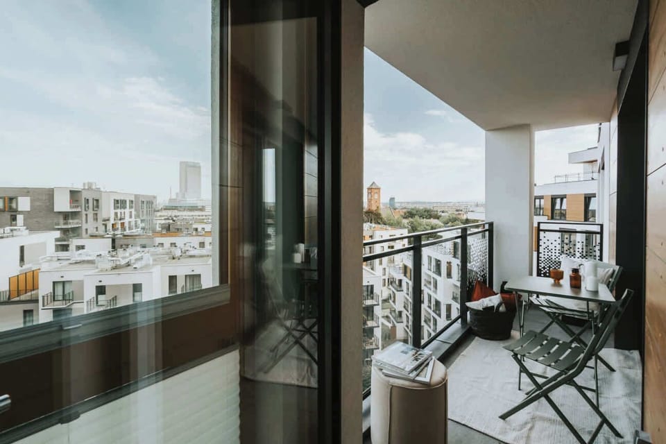 A cozy balcony with a small table and chairs, perfect for morning coffee or an evening glass of wine while enjoying the city view.