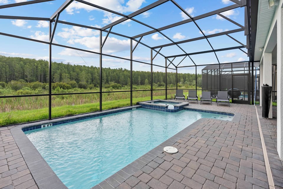 Step outside to your private pool oasis, surrounded by lush greenery and a modern screened enclosure. Relax in sleek, comfortable chairs, soaking up the sun or enjoying a good book amidst the soothing sounds of water.