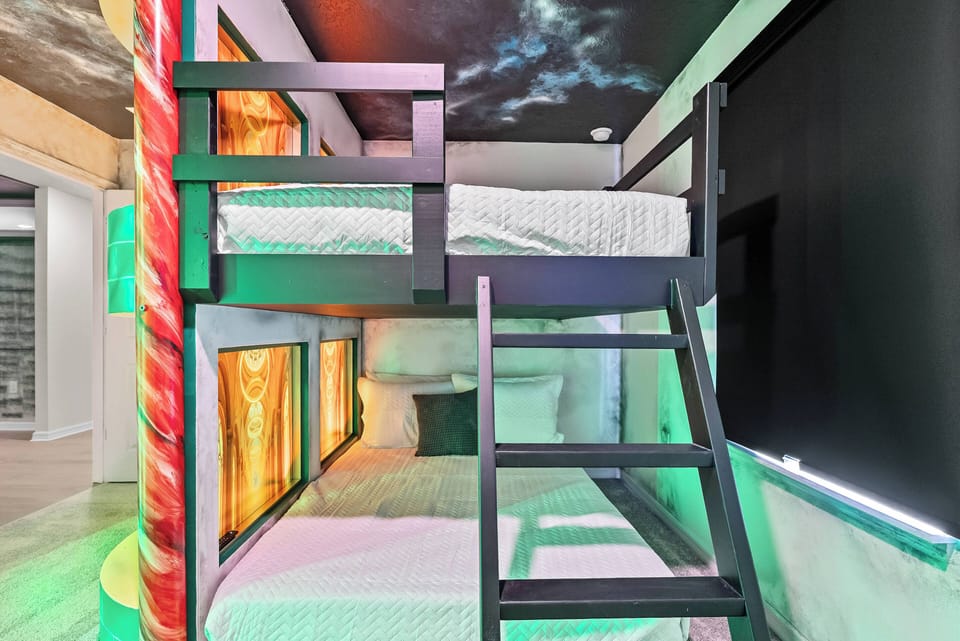 Enjoy a fun getaway in this uniquely designed bunk room, featuring vibrant colors and playful artwork that inspire imagination. The chic black wooden frame complements cozy bedding, ensuring restful nights for everyone.