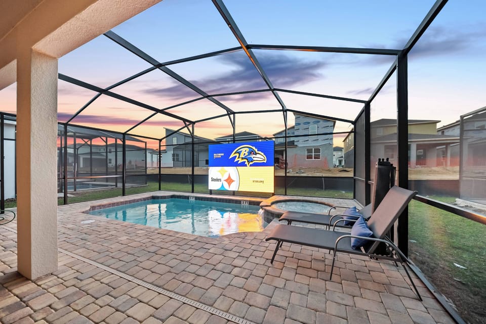 Relax by the poolside on sleek lounge chairs on the spacious paver patio. The screened enclosure adds comfort as you unwind, all while enjoying the stunning sunset backdrop that enhances your peaceful evening.