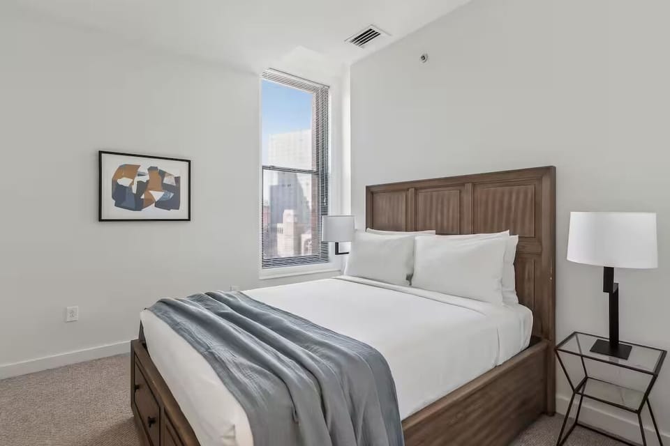 Unwind in crisp linens with calming city-light views.