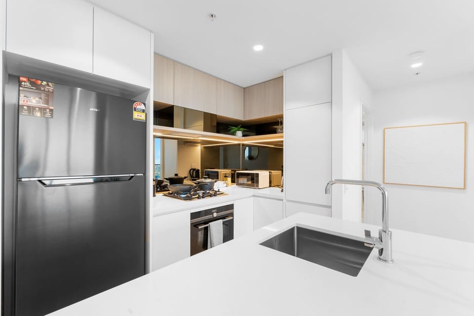 Sleek designer kitchen with Siemens appliances, featuring a full-sized fridge, gas cooktop, and premium finishes throughout.