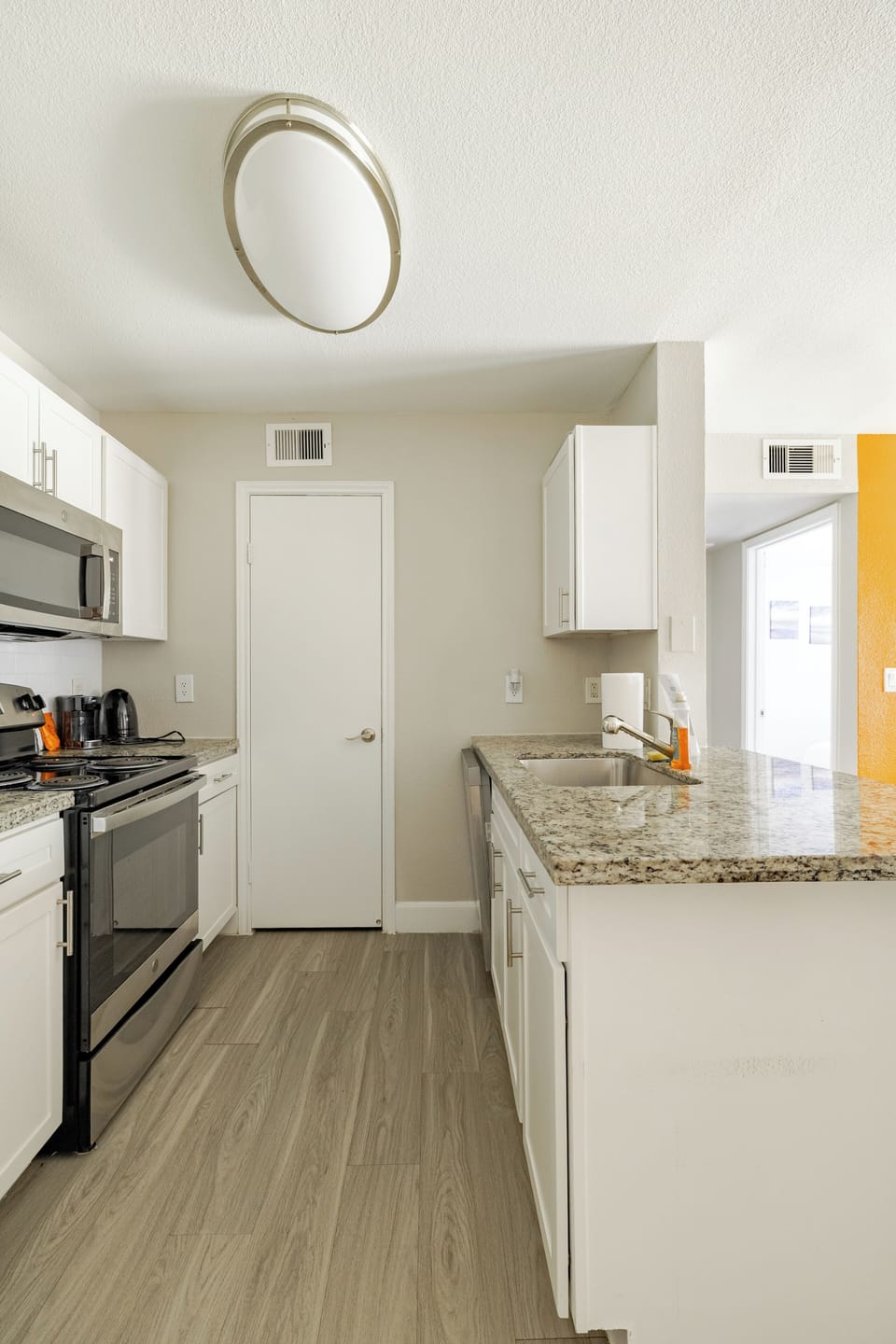 Bright modern kitchen with granite counters and stainless appliances