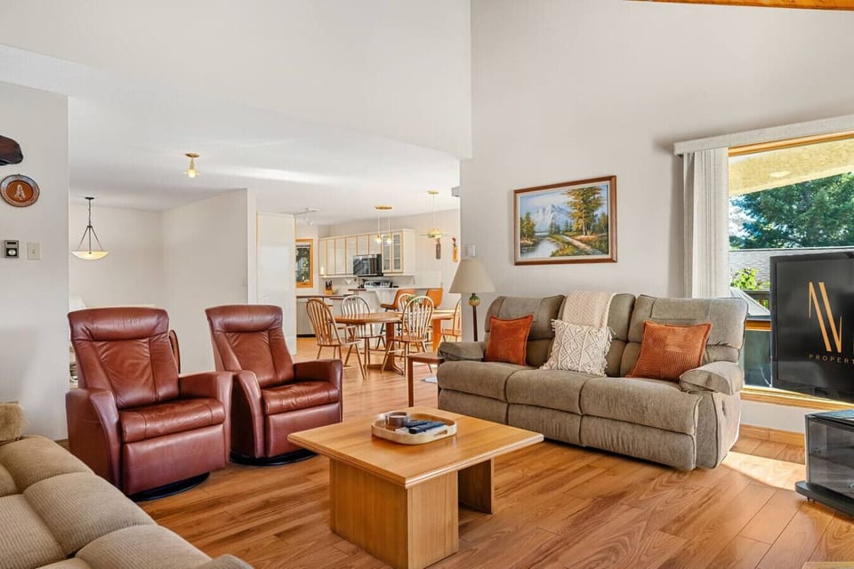 Main floor living room with a wood-burning fireplace, Smart TV, and cozy seating options with mountain and lake views.