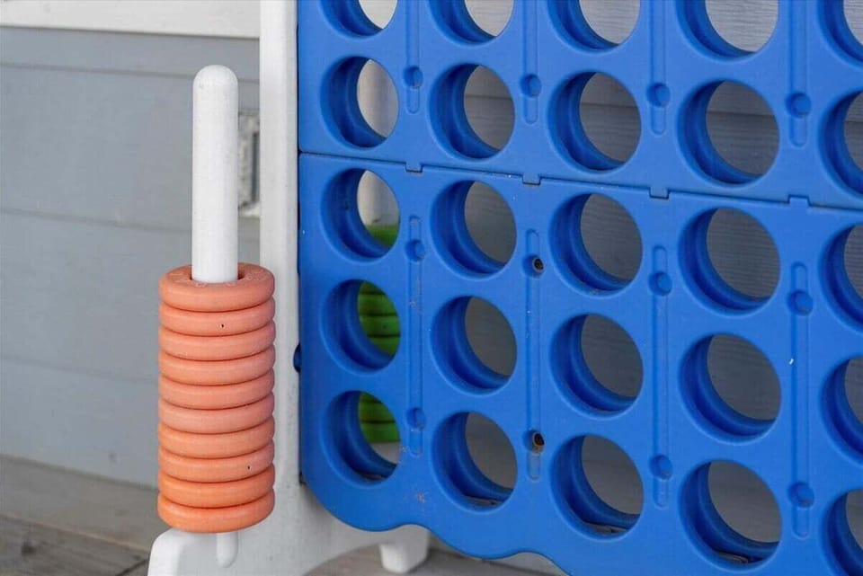 Outdoor game area with oversized Connect Four, great for family-friendly beach house entertainment.