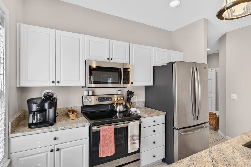 A fully equipped kitchen with stainless appliances and a Keurig.