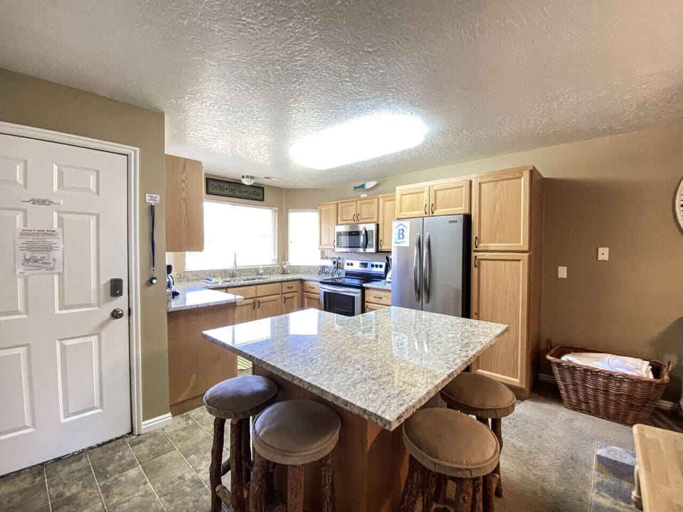 Granite island with bar seating anchors this bright, functional kitchen