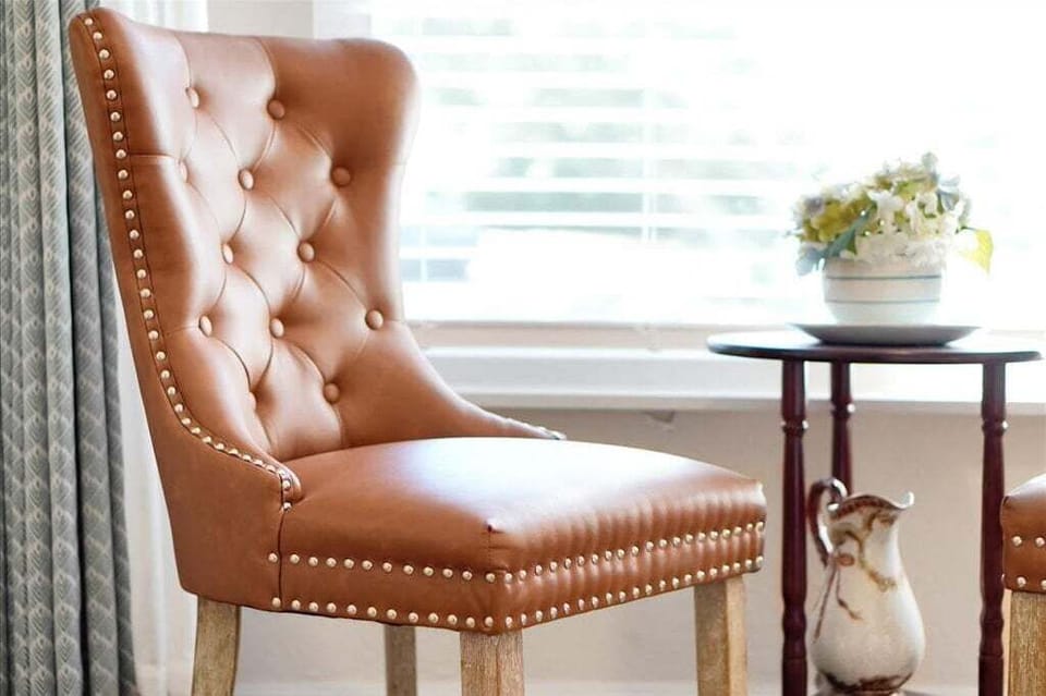 Every room is thoughtfully designed with stylish seating, like this classic leather wingback chair—perfect for a quiet moment of reading by the window.
