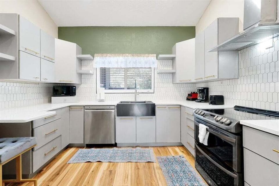 Cook with ease in this updated space, featuring sleek cabinetry, stainless steel appliances, and a beautiful farmhouse sink—perfect for family gatherings.