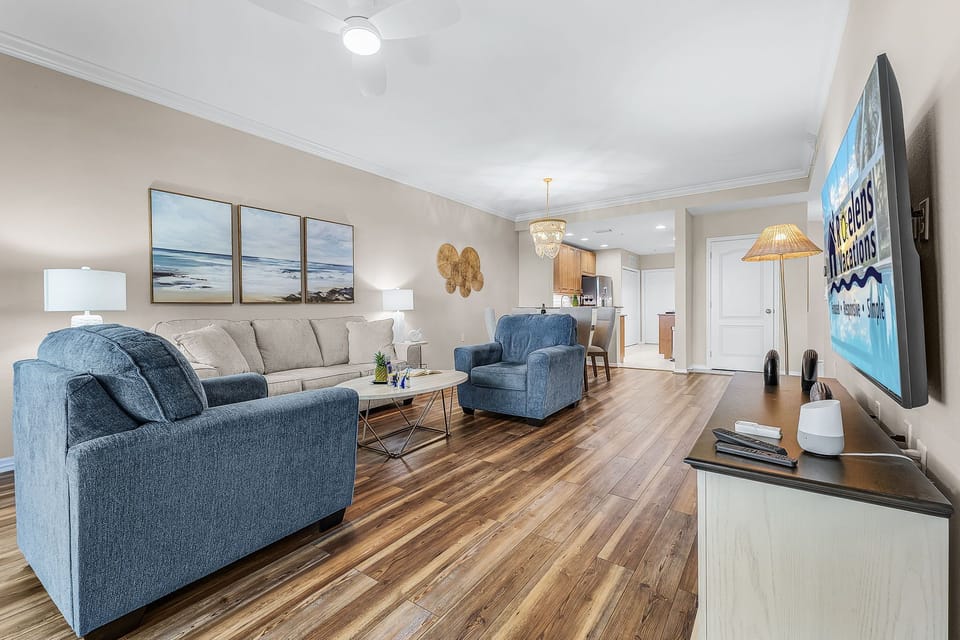 Spacious living area with new furnishings and TV.