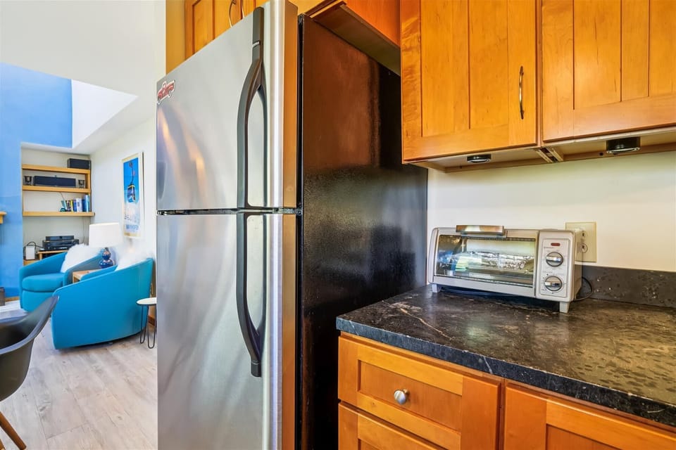 Convenient kitchen layout with full-size refrigerator, oven, microwave, and everything needed for easy meal prep.