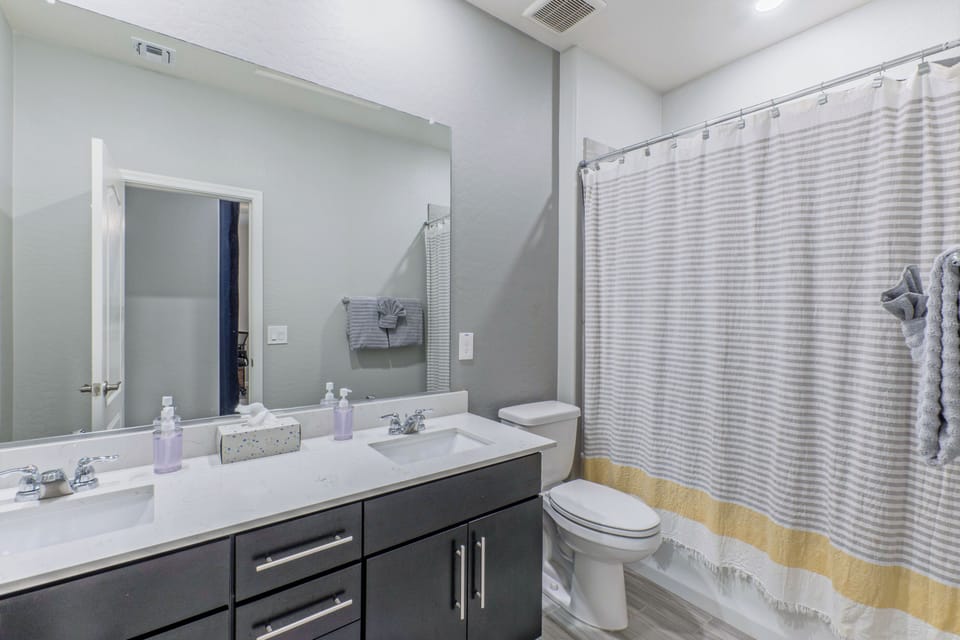 Bathroom 2 has a tub-shower combo and dual vanity sinks.