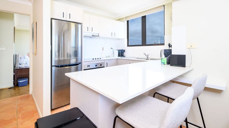 Bright and modern kitchen with breakfast bar and stainless steel appliances.