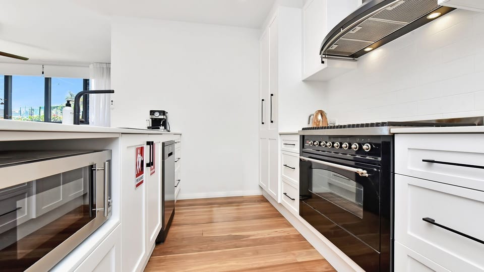 Sleek kitchen with quality appliances and timber floors