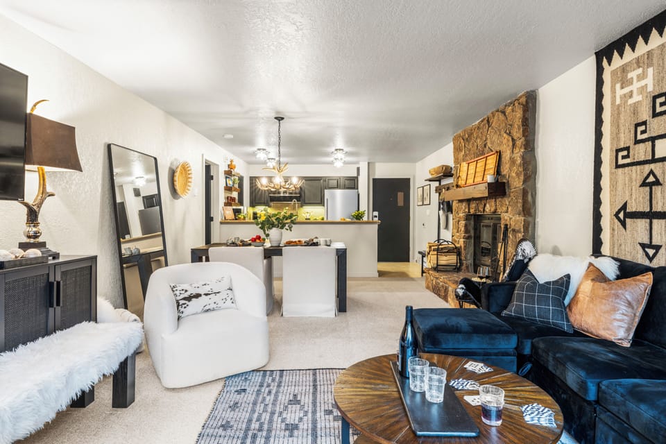 Cozy living room with comfortable seating, TV, fireplace and deck access.