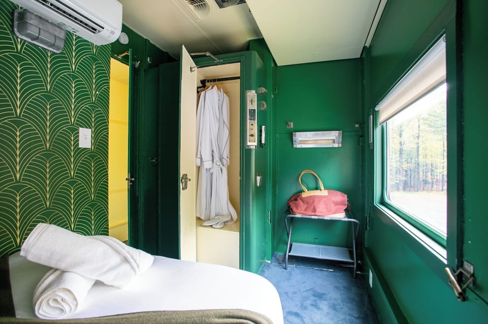 The Adirondack Suite equipped with a closet, bedside table, robes and slippers.