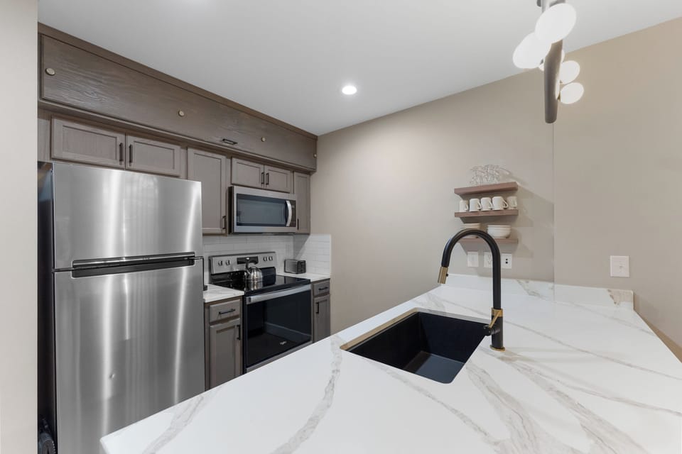 Your modern kitchen features elegant marble countertops, stainless steel appliances, and thoughtful design details for effortless meal preparation.