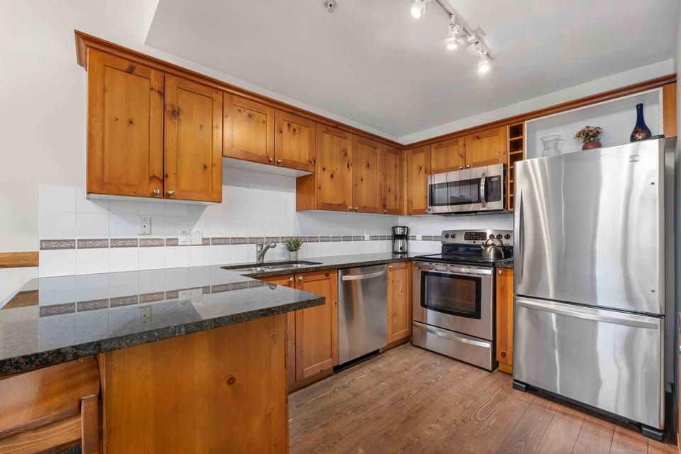 Fully equipped kitchen with granite counters and contemporary stainless steel appliances