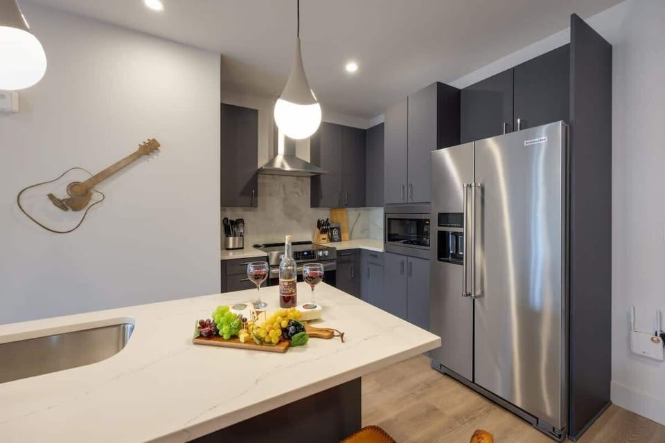 Chef-ready kitchen featuring high-end stainless steel appliances, ample dark cabinetry, and a bright stone countertop.