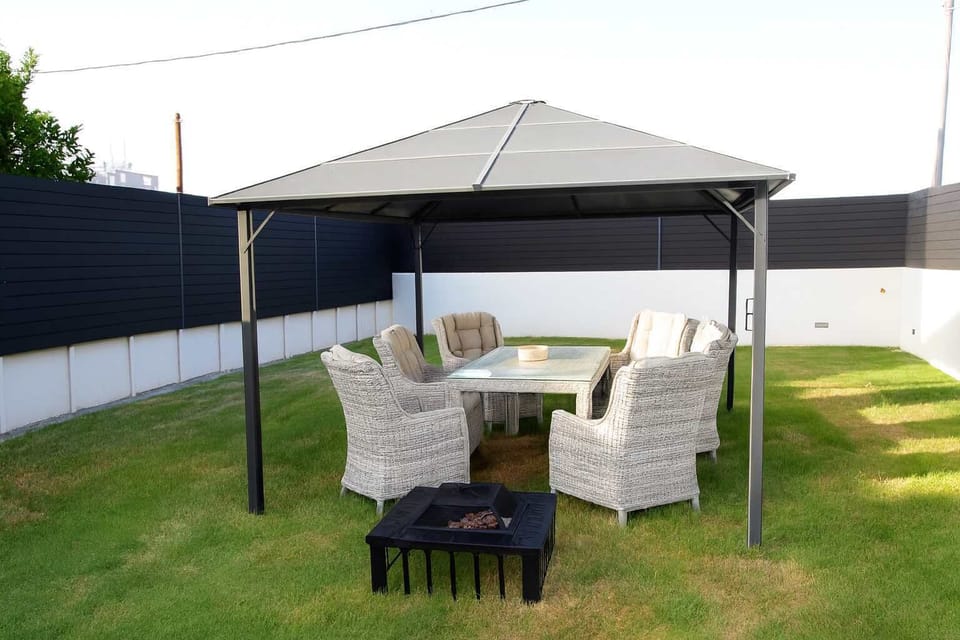 Cozy outdoor patio area with rattan seating.
Perfect for sunset drinks or morning coffee with a refreshing breeze. Shaded pergola ensures year-round comfort!