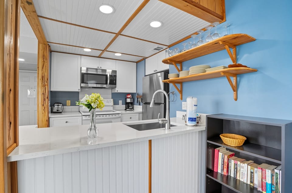 Kitchen Island with Open Shelving - Beadboard, wood accents, and open shelves give the kitchen useful prep and storage space.
