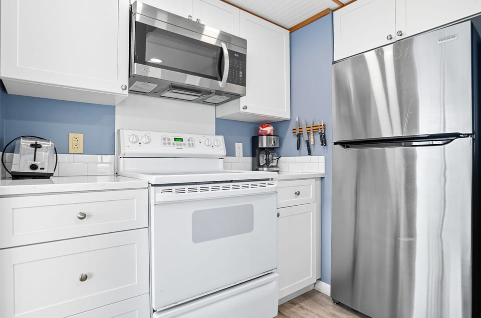 Kitchen Appliances and Coffee Setup - Refrigerator, range, microwave, and coffee station keep daily basics within easy reach.