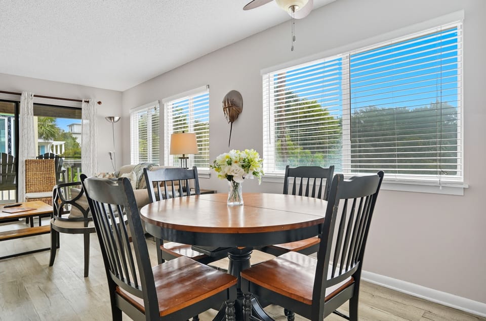 Dining Area with Natural Light - Window seating and open sightlines connect the table to the living room and balcony.
