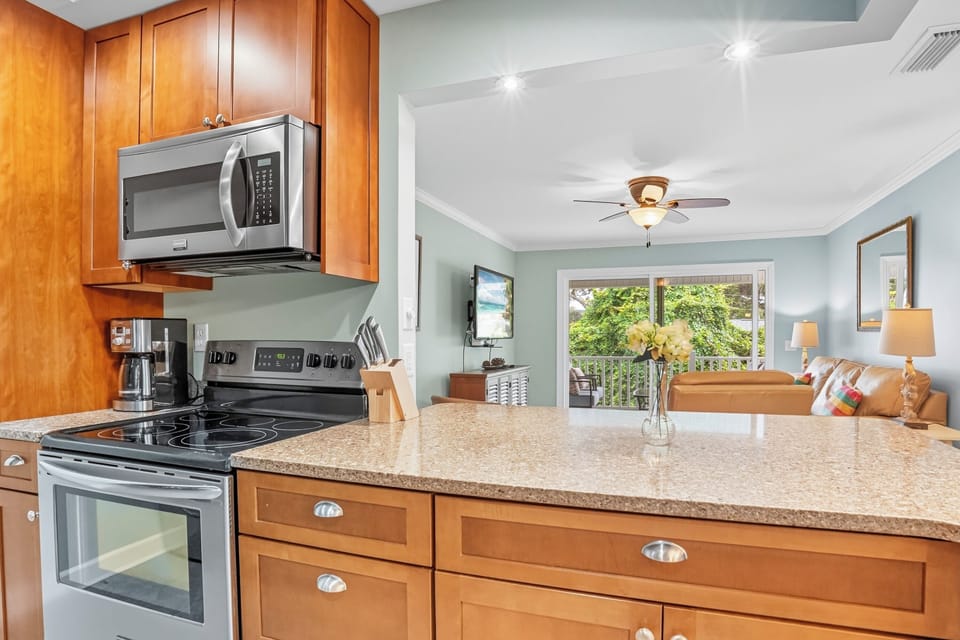 Fully Equipped Updated Kitchen - Granite counters, stainless appliances, and warm cabinetry give the condo a useful cooking setup.