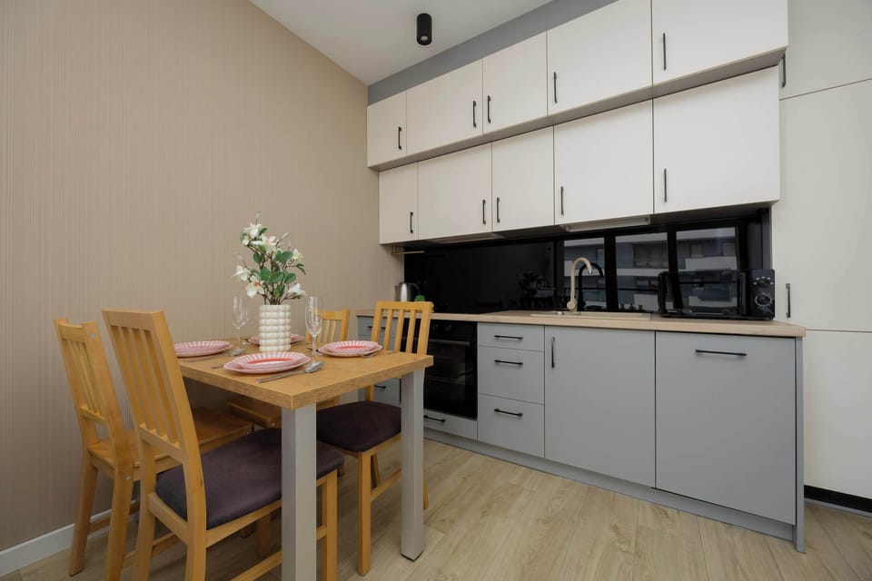 Fully equipped kitchen with oven, microwave, and black backsplash.
