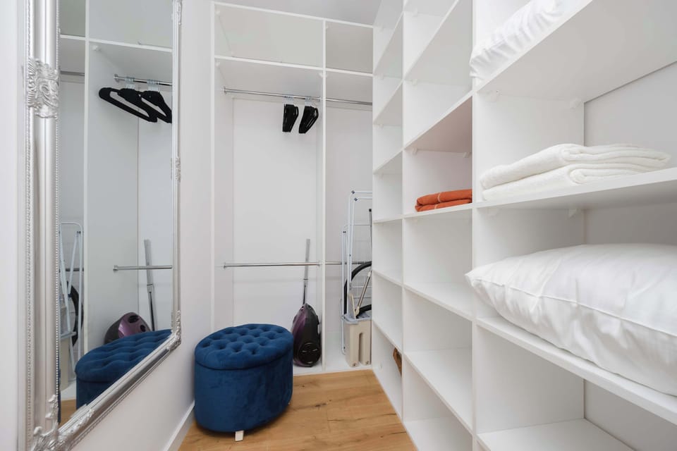 A wardrobe area with neatly arranged shelves, drawers, and hanging space. Organized storage boxes and clothes give the impression of order and functionality.
