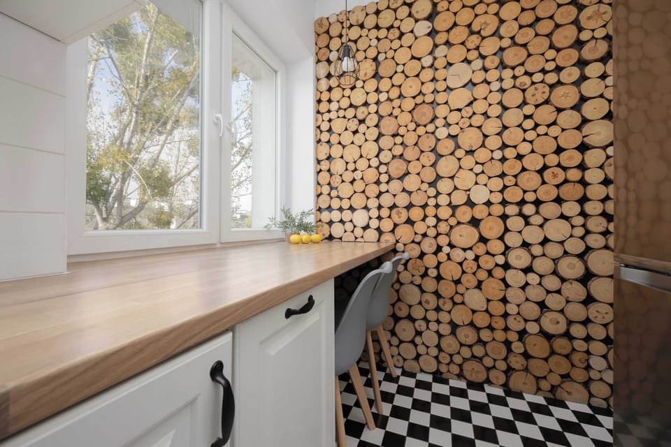A compact kitchen with bright white cabinets, a built-in oven, and black-and-white tiled flooring. The countertop provides a clean and practical workspace.