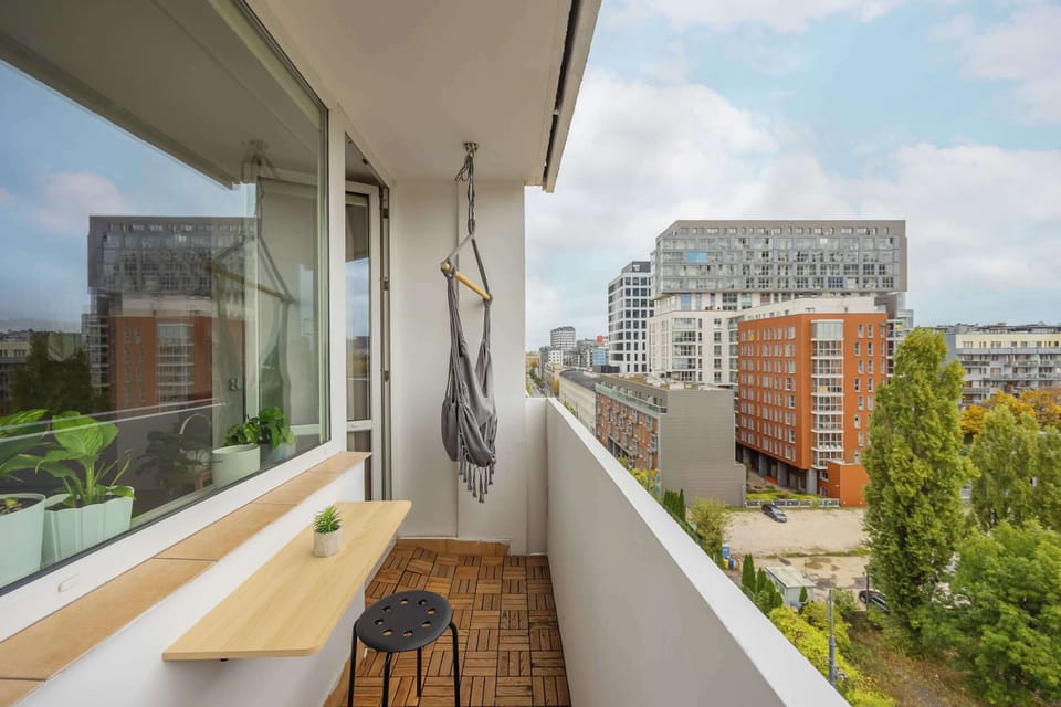 A cozy balcony offering views of the surrounding buildings and lush greenery.