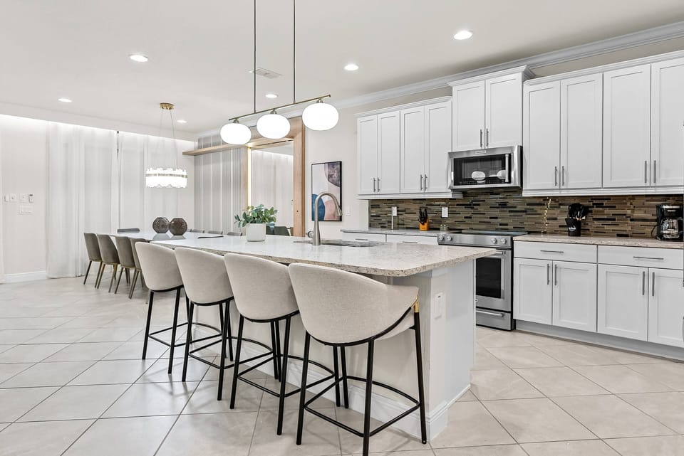 Welcome to this bright kitchen with sleek white cabinetry and a stylish tile backsplash, perfect for unleashing your culinary skills.