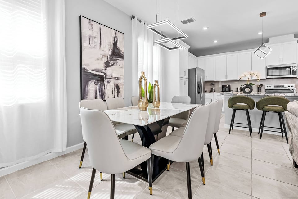 Enjoy the charm of this stylish dining area with a sleek marble-top table and elegant upholstered chairs. The bright natural light enhances the modern decor, creating a warm atmosphere perfect for your meals.