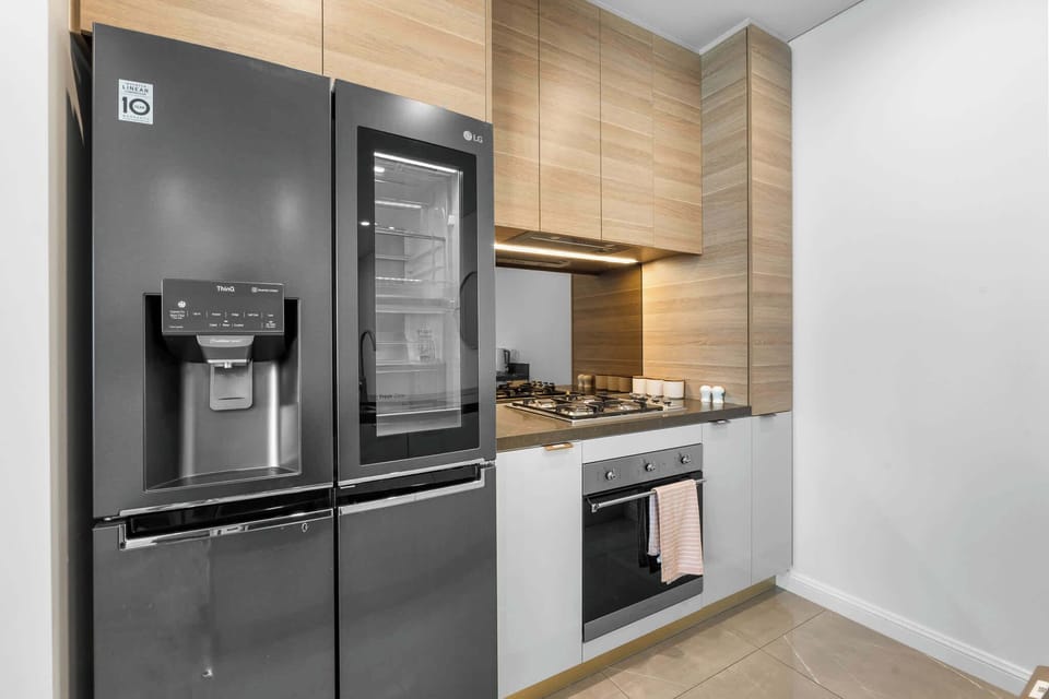 Contemporary design meets convenience with a full-sized LG InstaView fridge, gas cooking, and sleek integrated cabinetry.