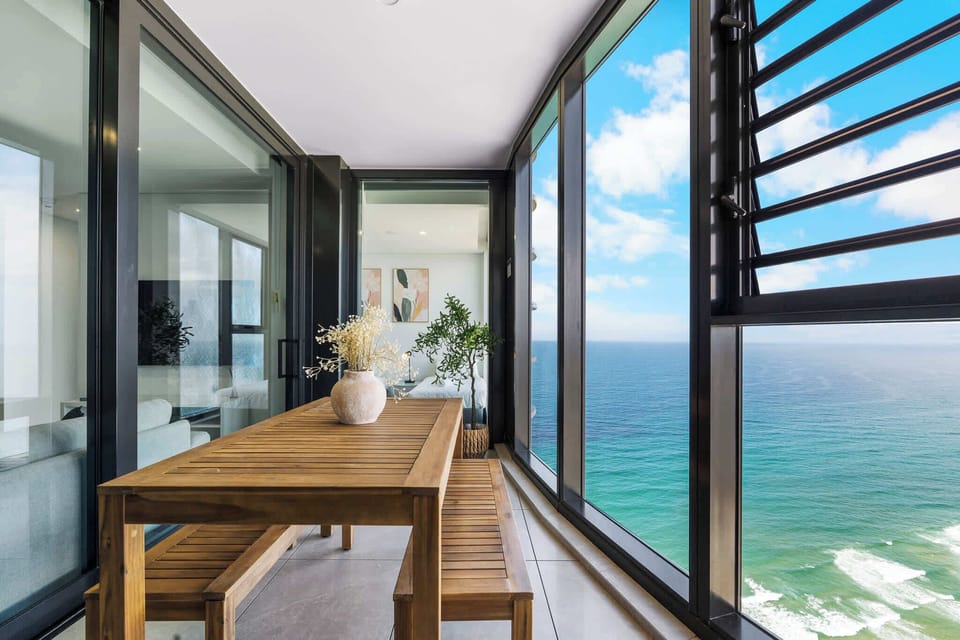 Wake up to breathtaking ocean views — the balcony’s wooden dining set is perfect for morning coffee or sunset wine.