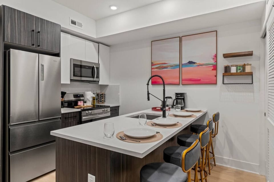 Dining area that seats 4 people with plates, mugs, and stainless steel flatware.
