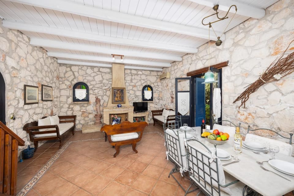 Open-plan living room with sofas, dining area, kitchen, ornamental fireplace, A/C, WiFi internet, and satellite TV