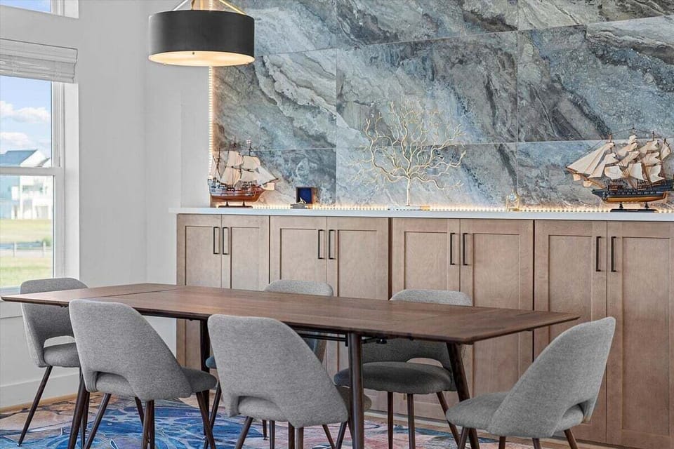 Designer accent wall and buffet area creating a stylish dining atmosphere in this Galveston beach rental.
