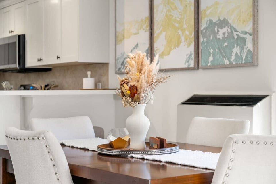 Dining area with access to the private balcony with a BBQ and outdoor seating.