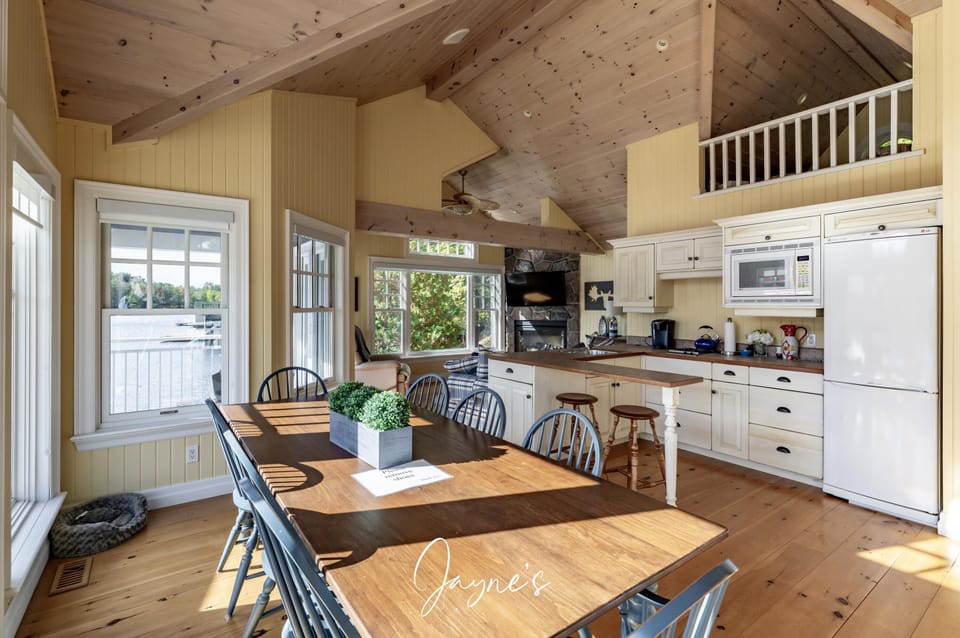 Sunlit kitchen and dining area with vaulted ceilings and cozy charm