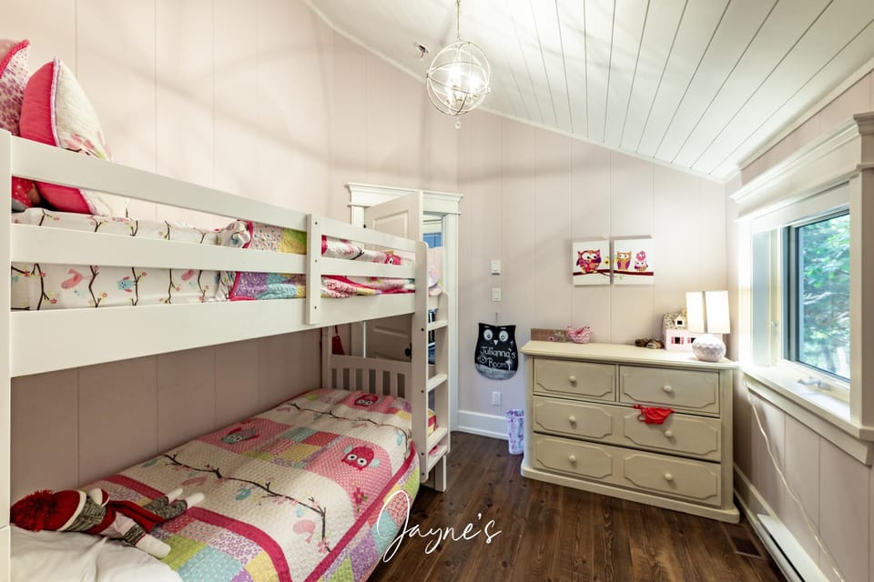 Cozy bunk bedroom with charming decor and natural light