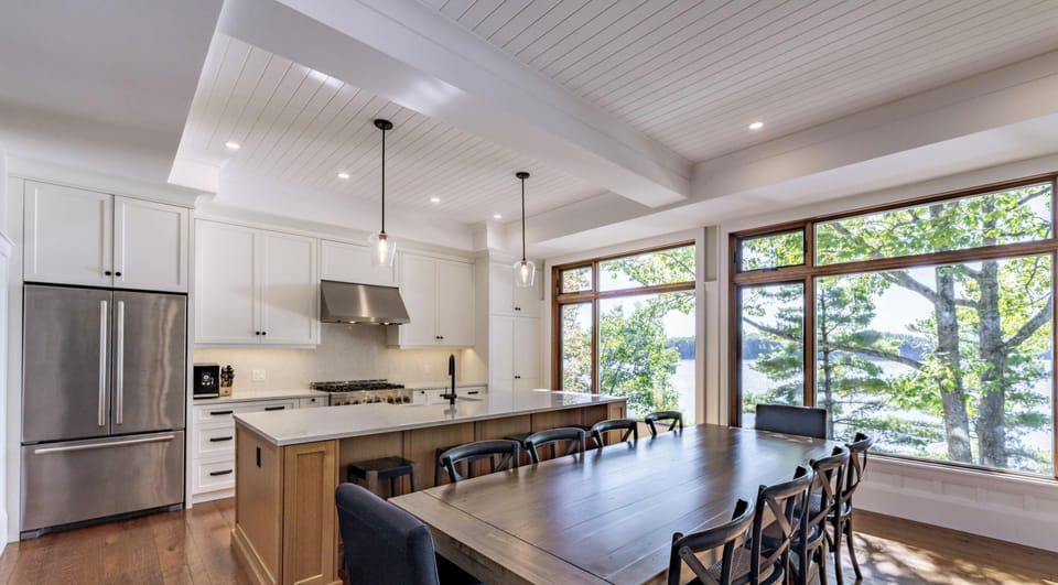 Sunlit dining area with scenic lake views and modern kitchen