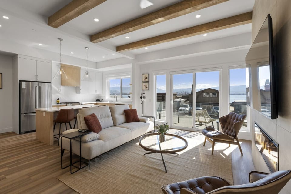 Relax in style in the spacious living room, featuring panoramic lake views and a cozy atmosphere for ultimate comfort.