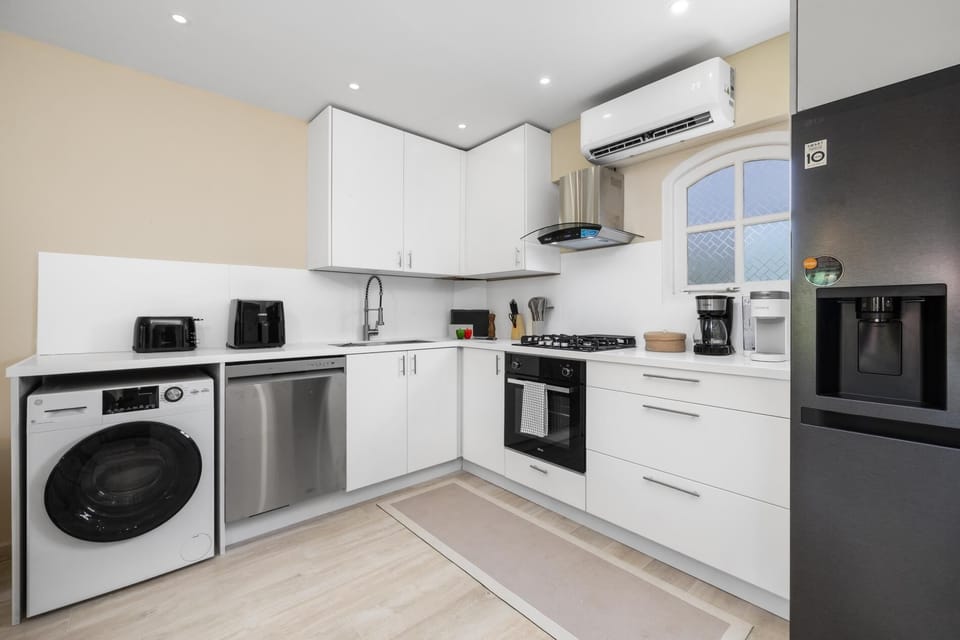 Cook and dine with ease in a fully equipped kitchen complete with modern appliances, cookware, and plenty of storage. The nearby dining table invites you to gather, share meals, and enjoy each moment together.